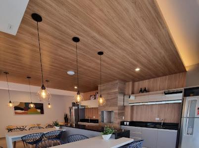 a kitchen with wooden ceilings and tables and chairs at Estúdio Lindíssimo com Varanda! in Curitiba