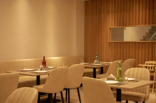 a dining room with tables and chairs and a screen at HILUX COURTYARD in Palakkad
