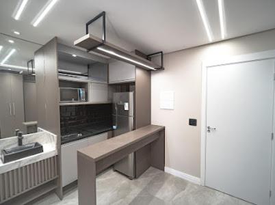 a kitchen with a sink and a stove top oven at Estúdio Lindíssimo com Varanda! in Curitiba