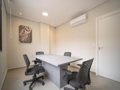 an office with a table and chairs in an office at Estúdio Lindíssimo com Varanda! in Curitiba