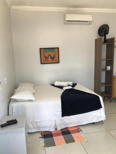 a bedroom with a large white bed in a room at Pousada Trilha do Sol in Pirenópolis