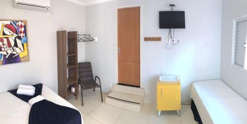 a bedroom with a bed and a tv in it at Pousada Trilha do Sol in Pirenópolis