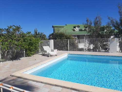 ein Pool vor einem Zaun in der Unterkunft Maison PAPAGAYO in Oyster Pond