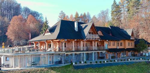 a large wooden house with a gambrel roof at Noclegi - Karczma Solina in Solina