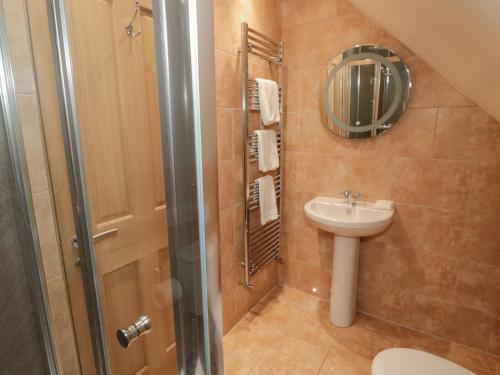 uma pequena casa de banho com um lavatório e um chuveiro em St Dolmen em Embleton