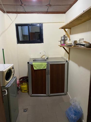 a small kitchen with a sink and a microwave at Studio meublé à Conakry in Conakry