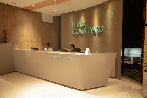 two people sitting at a reception desk in a lobby at HILUX COURTYARD in Palakkad