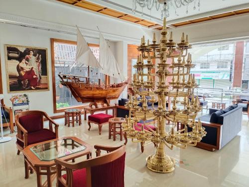 a living room with a chandelier and a boat on the wall at Presidency Kochi City Centre in Cochin