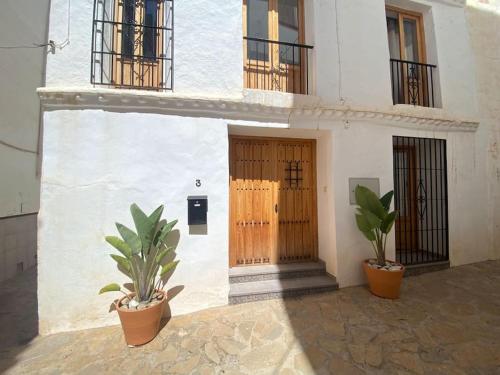 a building with two potted plants in front of it at Casa Palma in Cómpeta