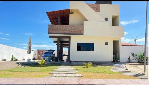 een groot wit huis met een dak bij POUSADA SOLAR DOS MOREIRAS in Guajiru