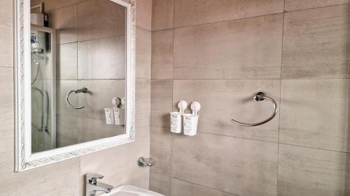 坎帕拉Eric Wilkins Apartments的带淋浴、水槽和镜子的浴室