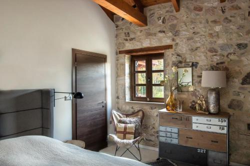 a bedroom with a bed and a dresser and a window at Villa MYLOS Kalavrita in Kalavrita