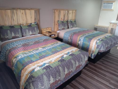 two beds sitting next to each other in a room at Aneth Lodge Budget 6 in Cortez