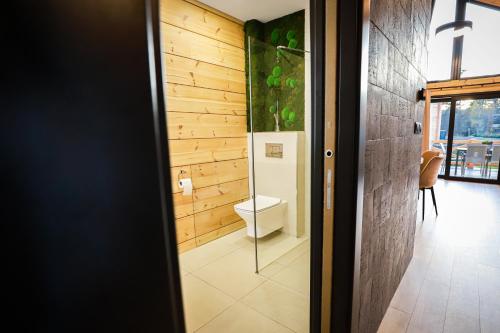 a bathroom with a toilet and a glass door at Vila Elis in Veľká Lomnica