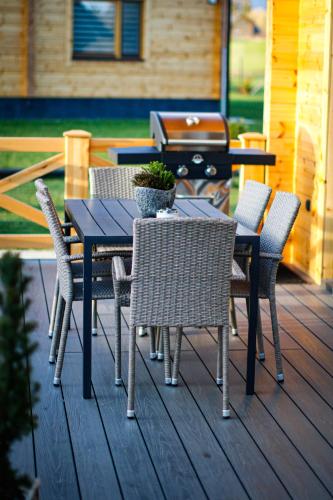 a table and chairs on a deck with a grill at Vila Elis in Veľká Lomnica