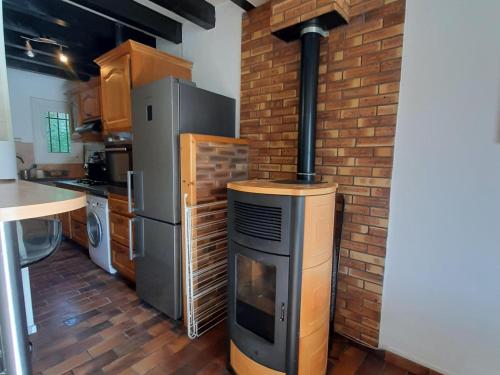 - une cuisine avec une cuisinière et un mur en briques dans l'établissement Grand appartement avec poêle, 2 chambres et dortoir près du village - FR-1-515-147, à Villard-de-Lans