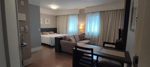 ein Hotelzimmer mit einem Bett und einem Sofa in der Unterkunft Moema Flat Luxo, Macuco in São Paulo