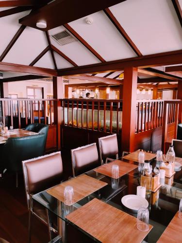 a dining room with wooden tables and chairs at Presidency Kochi City Centre in Cochin