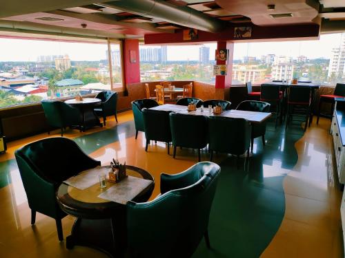 a restaurant with tables and chairs and a large window at Presidency Kochi City Centre in Cochin