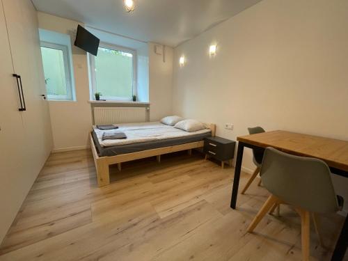 mały pokój z łóżkiem i stołem w obiekcie Modern guest house in city center I Room 3 w Wilnie