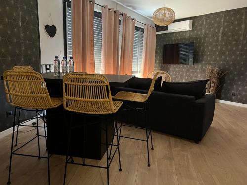 a living room with a bar with chairs and a couch at Perpignan Vauban magnifique T2 avec balcon in Perpignan