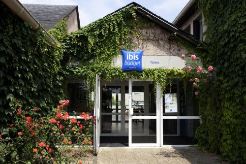 a blue door leading to a house with a balcony at ibis budget Tarbes in Tarbes