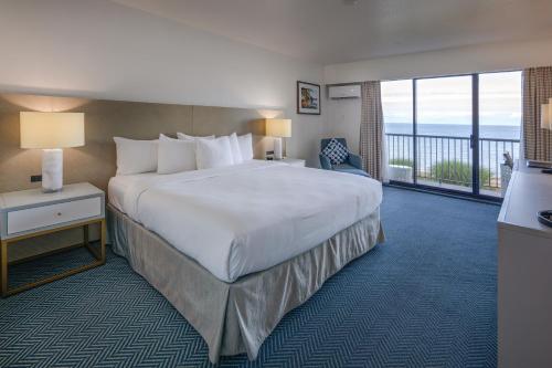 Habitación de hotel con cama grande y balcón. en Bayside Resort, Ascend Hotel Collection, en Parksville