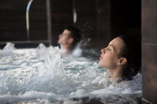 a man and a woman in a bathtub at Villa Delfin Spa in Świnoujście