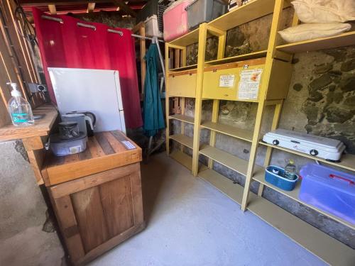 a room with yellow shelves and a white refrigerator at Les hamacs aux Saintes in Terre-de-Haut