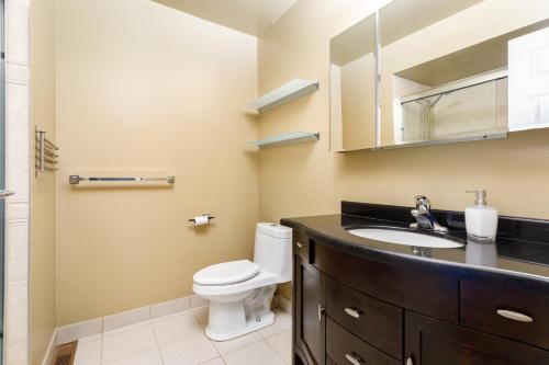 a bathroom with a toilet and a sink and a mirror at Spacious & Quiet 4bd House in Prime Location! Upper 2 Levels! in Mississauga