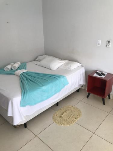 a bedroom with a bed and a nightstand and a bed sidx sidx at Pousada Trilha do Sol in Pirenópolis