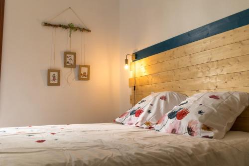 a bedroom with a bed with a wooden headboard and two pillows at MAISON NATURE ET DETENTE AUX PORTES DE LA BAIE in Chépy