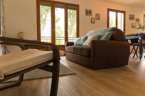 a living room with a couch and a table at MAISON NATURE ET DETENTE AUX PORTES DE LA BAIE in Chépy