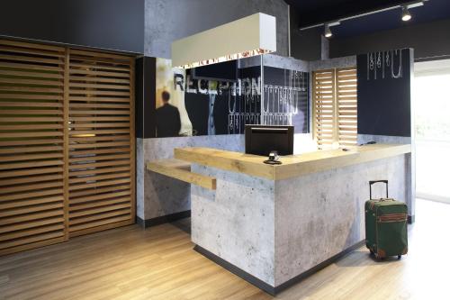 a lobby with a reception desk with a suitcase at ibis budget Tarbes in Tarbes