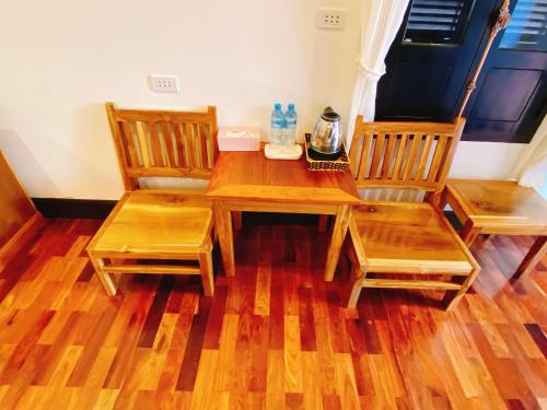 a wooden table with two chairs and a coffee maker on it at Opera Premier Hotel in Luang Prabang