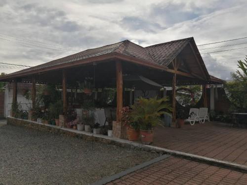 a pavilion with potted plants on a brick patio at Hotel Yurak in Archidona