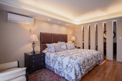 a bedroom with a large bed and a chair at Hotel del Parque in Matehuala