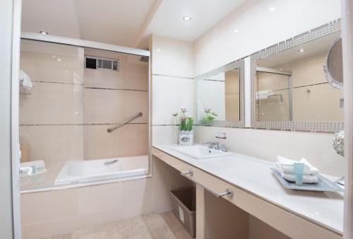 La salle de bains est pourvue d'un lavabo, d'une baignoire et d'un miroir. dans l'établissement Hotel del Parque, à Matehuala