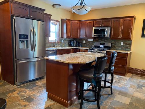 a kitchen with a stainless steel refrigerator and a table at Inn136 Guest House in Kingsville