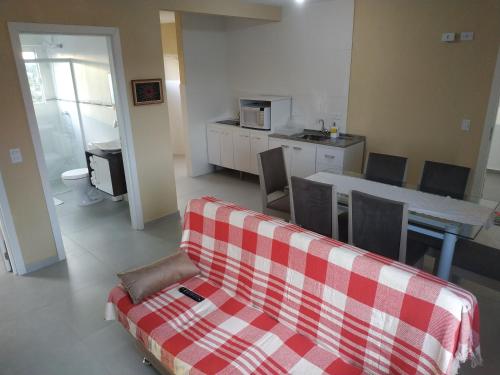 sala de estar con sofá, mesa y cocina en Apto Completo Praia Central Armação, en Penha