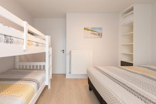 two bunk beds in a room with white walls at Villa Stijn in Middelkerke