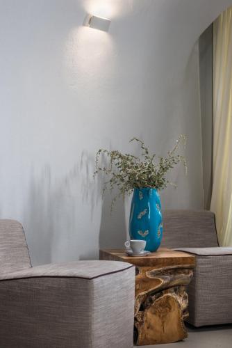 a blue vase sitting on top of a wooden table at Nefeles Luxury Suites in Fira