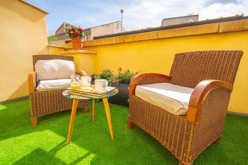 two wicker chairs and a table on a lawn at CARTAGENAFLATS, Apartamentos Calle Mayor, CITY CENTER in Cartagena