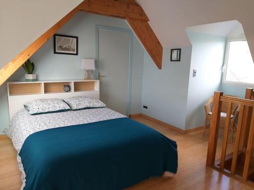 - une chambre avec un lit et une couverture bleue dans l'établissement Duplex de la Croix Paqueray avec vue mer - Chez Hélène - Gîtes en baie, à Carolles