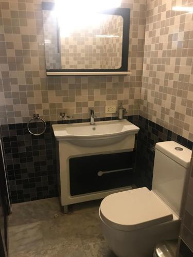 a bathroom with a white toilet and a sink at Sunset Inn in Monrovia