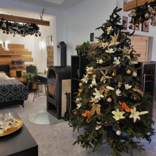 a christmas tree in a living room with a fireplace at Apartment Villa Hřensko 132 in Hřensko