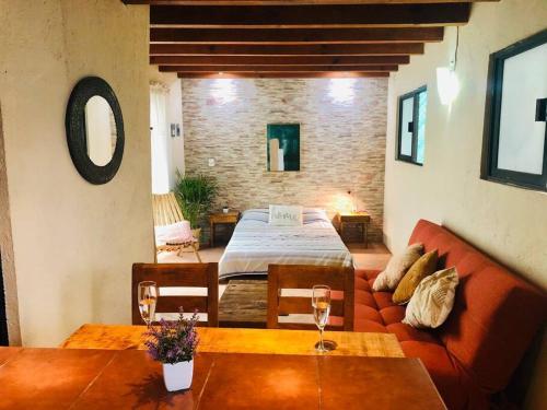 ein Wohnzimmer mit einer Couch und einem Bett in der Unterkunft RUSTIK Hermoso Rinconcito olivo(5 min centro) in Valle de Bravo