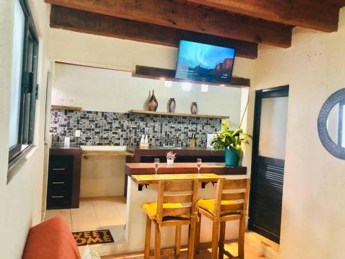 eine Küche mit Tisch und Stühlen und einem Fernseher in der Unterkunft RUSTIK Hermoso Rinconcito olivo(5 min centro) in Valle de Bravo
