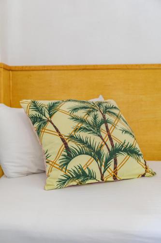 a pillow with a palm tree on a bed at Hostal El Perelló, Valencia in El Perelló