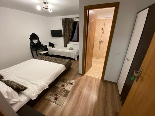 a small bedroom with a bed and a bathroom at Casa Moșoiu in Bran